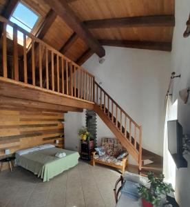 a bedroom with a bed and a wooden staircase at B&B Le Mimose in Bricherasio