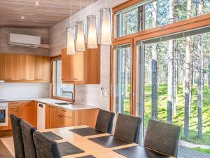 a kitchen with a table and chairs and a large window at Holiday Home Koukunmaja by Interhome in Kuusamo