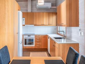 a kitchen with wooden cabinets and a table with chairs at Holiday Home Koukunmaja by Interhome in Kuusamo