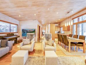 a living room with a table and a piano at Holiday Home Koukunmaja by Interhome in Kuusamo +34 photos