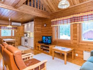 a living room with a couch and a tv in a cabin at Holiday Home Revontuli by Interhome in Ruka