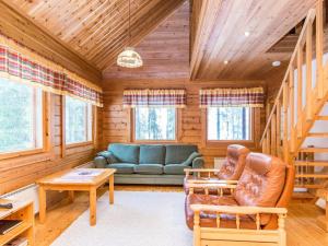 a living room with a couch and a table at Holiday Home Revontuli by Interhome in Ruka