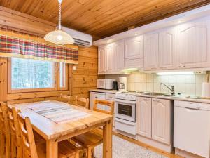 a kitchen with a wooden table and a wooden ceiling at Holiday Home Revontuli by Interhome in Ruka