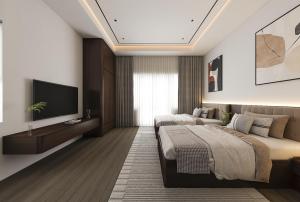 a bedroom with two beds and a flat screen tv at De' Mon Villa in Làng Tong Tchoung