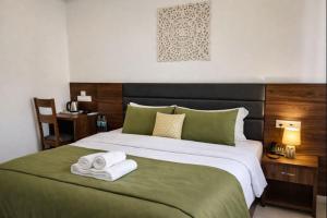 a bedroom with a large bed with towels on it at Ima Ganga Hotel - Aesthetic, Quite Mountain View Rooms In Upper Tapovan with netflix, free airport pickup for 7 or more nights booking in Rishīkesh