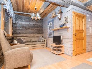 a living room with a couch and a tv at Holiday Home Pajalan honka by Interhome in Kuusamo