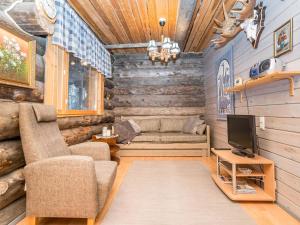 a living room with a couch and a tv at Holiday Home Pajalan honka by Interhome in Kuusamo