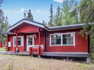 a red tiny house with a porch at Holiday Home Joutilas by Interhome in Ruka
