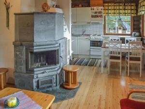 a living room with a fireplace in a kitchen at Holiday Home Honkapirtti- vuotunki by Interhome in Kunnari