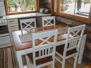 a kitchen with a wooden table and two chairs at Holiday Home Honkapirtti- vuotunki by Interhome in Kunnari