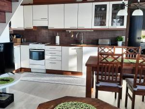 a kitchen with white cabinets and a table and chairs at Holiday Home Loisteranta by Interhome in Vääräkoski