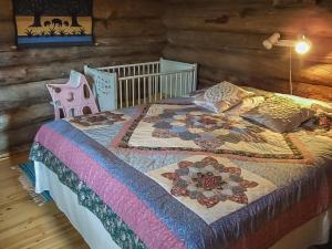 a bed with a quilt on it in a room at Holiday Home Honkapirtti- vuotunki by Interhome in Kunnari +25 photos
