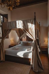 ein Schlafzimmer mit Himmelbett und Vorhängen in der Unterkunft Monte Pacis Hotel In Pažaislis in Kaunas