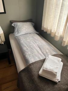 a bed with white sheets on it with a window at Riverfront romantic Asgardur vacation home of comfort in Selfoss