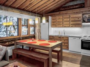 a kitchen with a table and a refrigerator at Holiday Home Rantaruka 4d1 by Interhome in Ruka