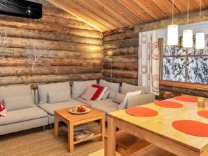 a living room with a couch and a table at Holiday Home Rantaruka 4d1 by Interhome in Ruka
