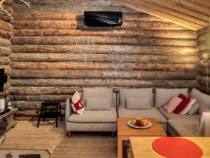 a living room with a couch and a wooden wall at Holiday Home Rantaruka 4d1 by Interhome in Ruka