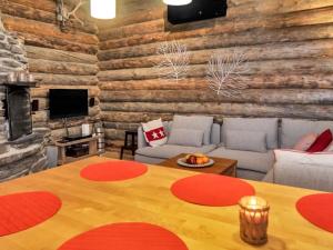 a living room with a table and a wooden wall at Holiday Home Rantaruka 4d1 by Interhome in Ruka +14 photos