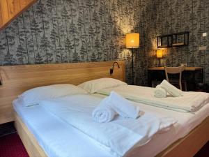 a bedroom with two beds with towels on them at Horský hotel Vidly in Karlova Studánka