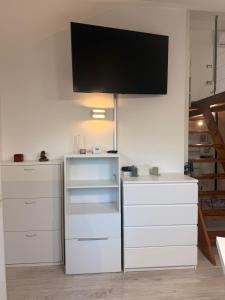 a room with white drawers and a flat screen tv at Avigliana Einaudi in Avigliana