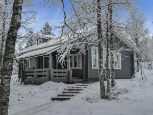 a house covered in snow with trees in front of it at Holiday Home Kallentupa by Interhome in Ruka