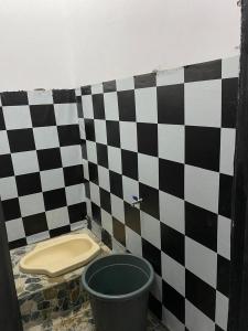a bathroom with a black and white checkered wall at WD adventure Pangalengan in Palayangan