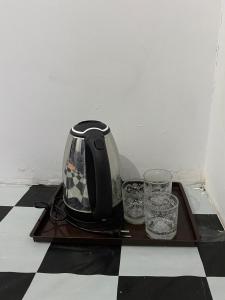a tea kettle and two glasses on a wooden tray at WD adventure Pangalengan in Palayangan