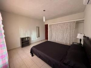 a bedroom with a black bed and a window at Sagitario dpto in Tuxtla Gutiérrez