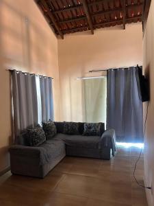 a living room with a couch and a television at casa passos e reis in Corumbau