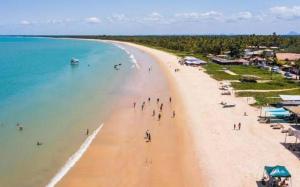 a group of people walking on a beach at casa passos e reis in Corumbau