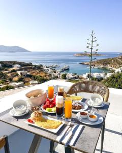 a breakfast table with breakfast foods and a view of the ocean at Milaki Kimolos in Kimolos