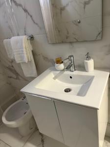 a white bathroom with a sink and a toilet at Agriturismo il Casale in Ponte Galeria