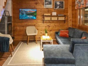 a living room with two couches and a tv at Holiday Home Joutsen a by Interhome in Ruka
