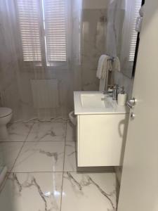 a white bathroom with a sink and a toilet at Agriturismo il Casale in Ponte Galeria