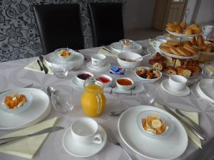 a table with white plates and bowls of food on it at Maison de Luciné in Combourg +55 photos