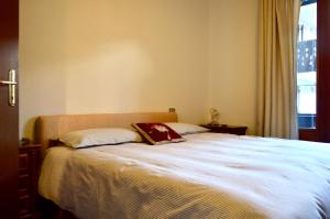a bedroom with a large bed with two pillows at Casa Alpina Place in Isolaccia