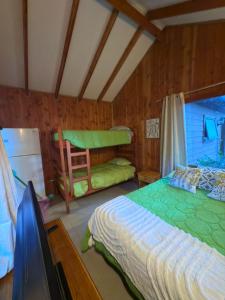a bedroom with a bed and a bunk bed at Cabañas en Pucón CASA TUWA in Pucón
