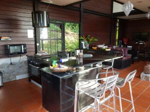 a kitchen with a counter and chairs in a room at Villa THEOROM in Chambort