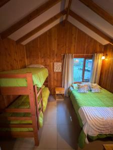 a bedroom with two bunk beds and a window at Cabañas en Pucón CASA TUWA in Pucón