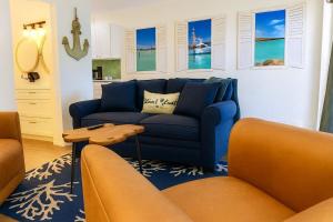 a living room with a blue couch and a table at 107 · Boat dock- BBQ Walk to Beach GREAT VIEWS in St. Pete Beach