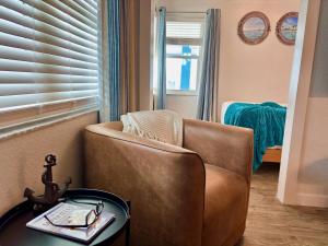 a living room with a brown chair and a table at 107 · Boat dock- BBQ Walk to Beach GREAT VIEWS in St. Pete Beach +83 photos