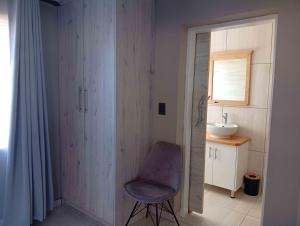 a bathroom with a chair next to a sink at Joyful Home Bela-Bela in Bela-Bela