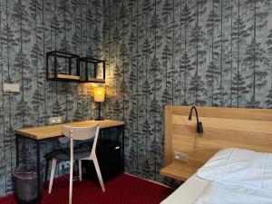 a bedroom with a desk and a bed and a bed and a bedskirts at Horský hotel Vidly in Karlova Studánka