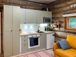 a kitchen with white cabinets and a stove top oven at Holiday Home Keloveska by Interhome in Ruka
