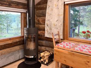 a wood stove in a room with a table and window at Holiday Home Keloveska by Interhome in Ruka