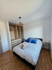 a bedroom with a bed with blue pillows at Tiboulen - Ste Luce sur Loire in Sainte-Luce-sur-Loire