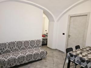 a living room with a couch and a table at Hd Guesthouse Oasi urbana con parcheggio privato gratuito, fronte stazione in Chivasso