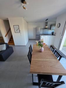 a dining room table with a vase of flowers on it at Tiboulen - Ste Luce sur Loire in Sainte-Luce-sur-Loire