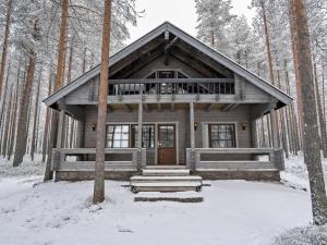a log cabin in the woods in the snow at Holiday Home Kitkaranta by Interhome in Kitka