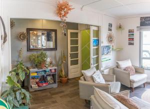 a living room with a couch and chairs and a mirror at Hostel Kuntur in Puerto Natales